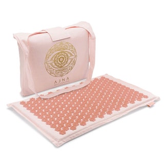 An accupressure mat from Ajna in blush with matching carrier bag  on a white background